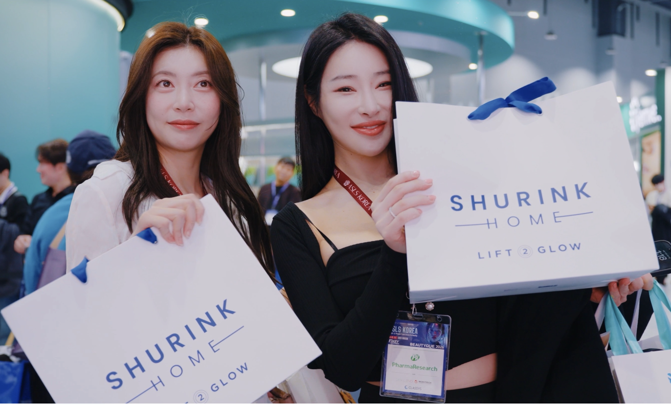 지난 뷰티크 현장에서 두 참가자가 슈링크 홈 쇼핑백을 들고 미소 짓는 모습