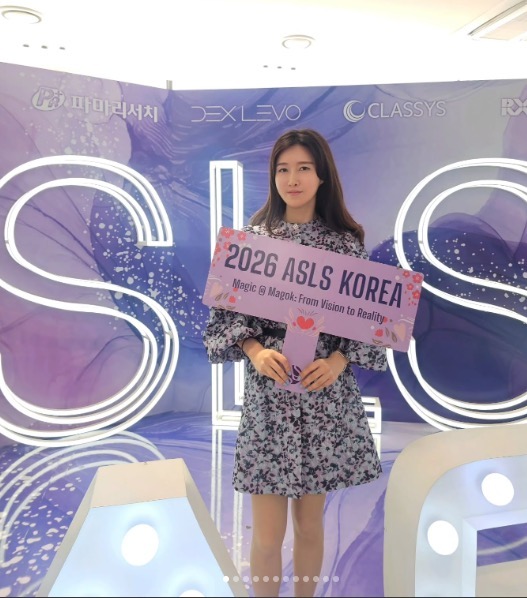 ASLS KOREA 포토존에서 행사 안내판을 들고 촬영한 방문 사진